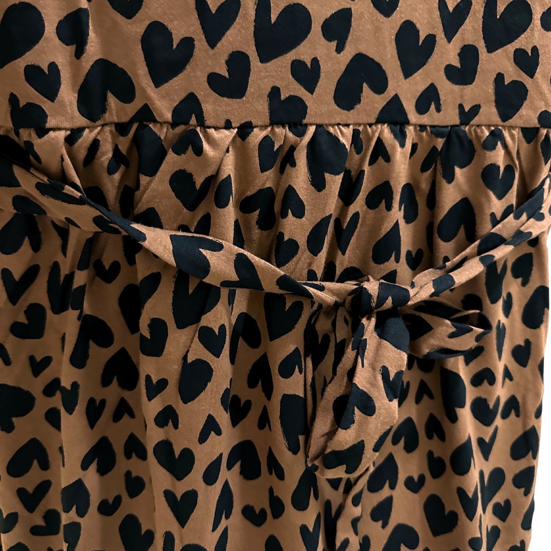 Brown with black small hearts midi length dress, v neck, puffed elbow length sleeves, ties around back shown to tighten as needed, front flap for easy breastfeeding and pumping access.
