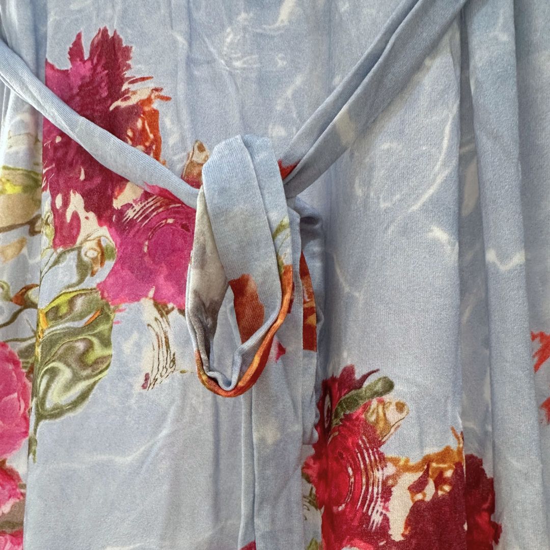 Blue Maxi length dress with large pink and red floral pattern. Soft material. Elbow length sleeves. V neck. Front flap access for easy breastfeeding and pumping. Ties around the back showcased for tightening as needed.