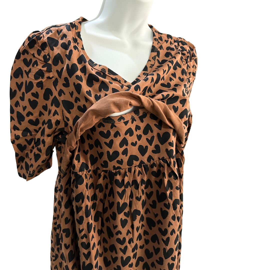 Brown with black small hearts midi length dress, v neck, puffed elbow length sleeves, ties around back to tighten as needed, front flap shown open for easy breastfeeding and pumping access.