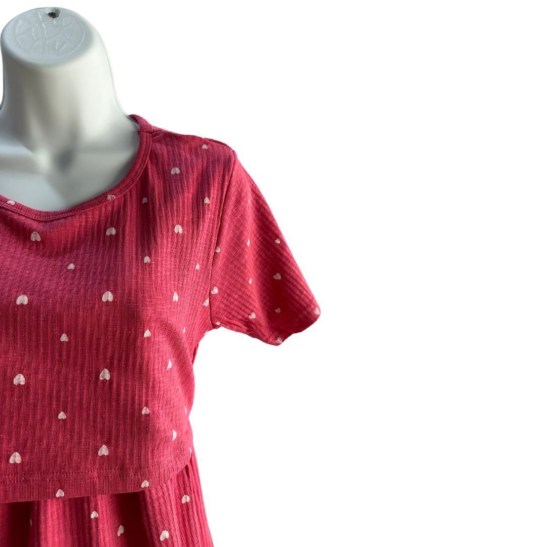 Pink with small white hearts, ribbed material, scoop neck, short sleeves, calf length dress. Front flap for easy breastfeeding and pumping. Tie around back for tightening as needed.